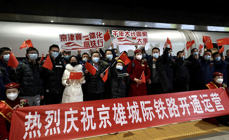 Los pasajeros y los miembros de la tripulación del tren se hacen fotos antes de subir al tren de alta velocidad que une Beijing y la Nueva área de Xiong′an, en la Estación de Ferrocarriles Oeste de Beijing, el 27 de diciembre de 2020. [Foto de Zou Hong / chinadaily.com.cn]