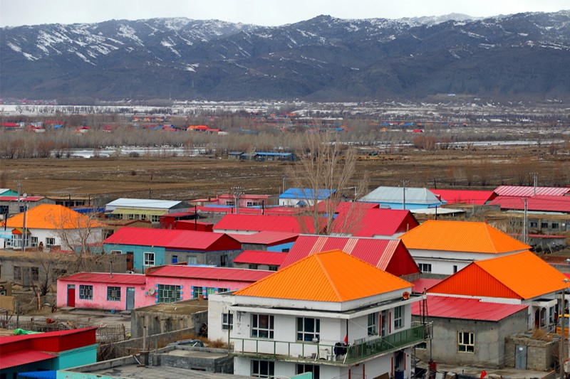 Pintoresca vista formada por coloridos edificios residenciales y monta?as cubiertas de nieve en el condado de Burqin, Altay, Región Autónoma de Xinjiang Uygur, 26 de marzo del 2021. (Foto: Pueblo en Línea/Wang Jianfeng)