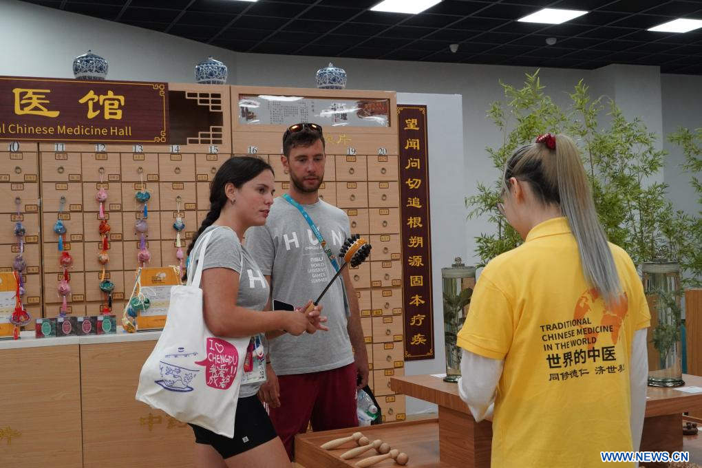 Imagen del 2 de agosto de 2023 de la atleta húngara, Anna Poltz (i) y su compa?ero de equipo aprendiendo sobre una herramienta de cuidado de la salud de medicina tradicional china (MTC) en la Aldea de los Juegos de la FISU, en Chengdu, en la provincia de Sichuan, en el suroeste de China. (Xinhua/Tang Wenhao)