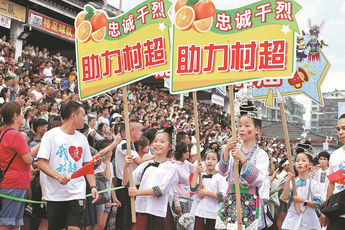 Ni?os vestidos con trajes tradicionales de grupos étnicos animan durante un juego de la "Super Liga de Aldeas", 28 de julio del 2023. (Foto: Zhu Xingxin/ China Daily)