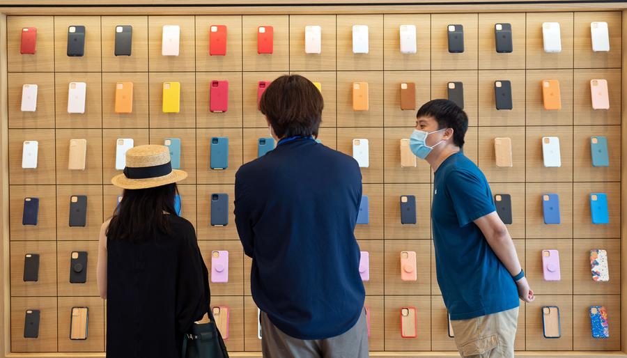 Imagen del 16 de julio de 2020 de un trabajador mostrando las carcasas de los teléfonos celulares durante una vista previa en la nueva tienda minorista de Apple, en el barrio de Sanlitun de Beijing, capital de China. (Xinhua/Cai Yang) 