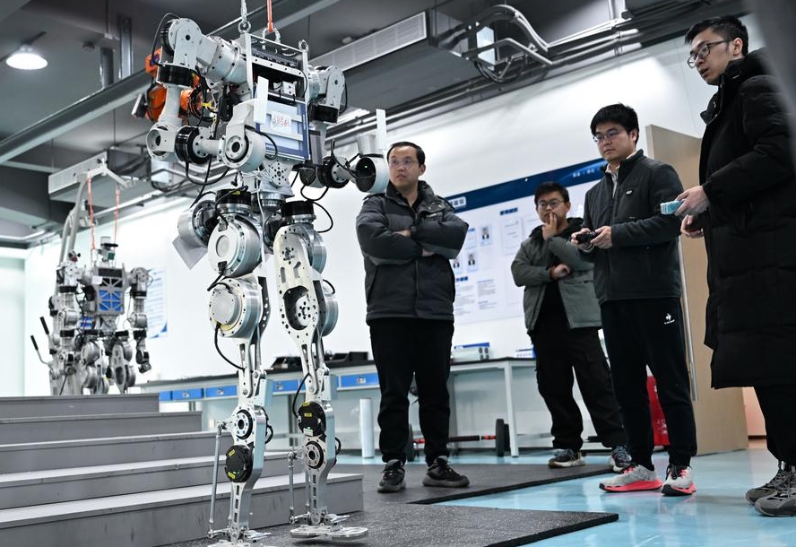 Miembros del equipo de investigación y desarrollo de Wuhan Glory Road Intelligent Technology Co., Ltd. depuran robots humanoides en la sede de la compa?ía, en Wuhan, capital de la provincia central china de Hubei, el 24 de febrero de 2025. (Xinhua/Du Zixuan)