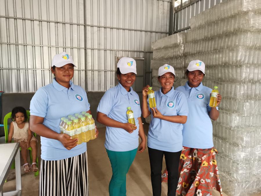 Aldeanas posan con botellas de detergente en una fábrica de un proyecto de cooperación con ayuda de China para la mitigación de la pobreza, en la provincia de Kandal, en Camboya, el 31 de julio de 2020. (Xinhua)
