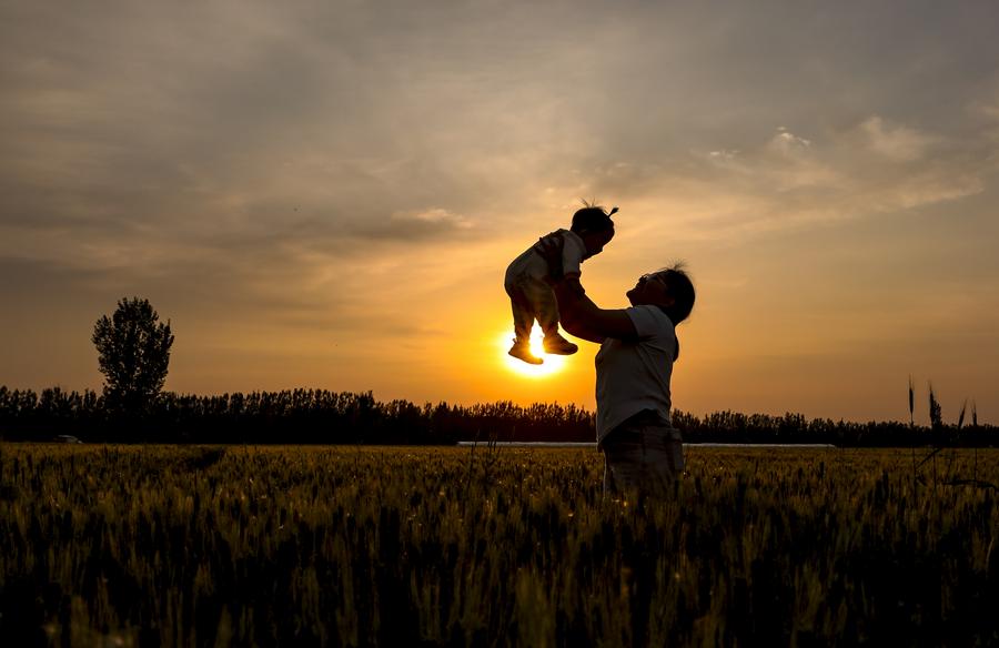 Una madre se divierte con su hijo en un campo de trigo en el distrito de Gaoqing de la provincia oriental china de Shandong, el 10 de mayo de 2025. (Xinhua/Zhang Weitang)