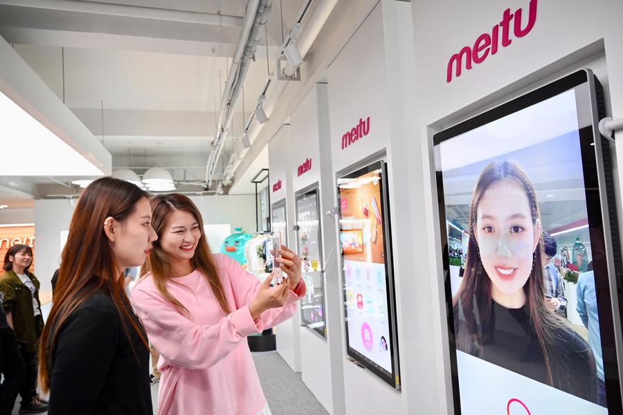 Empleadas toman una foto con la aplicación Meitu en la sala de exposiciones de la empresa en Xiamen, provincia de Fujian, en el este de China, el 10 de noviembre de 2020. (Xinhua/Jiang Kehong)