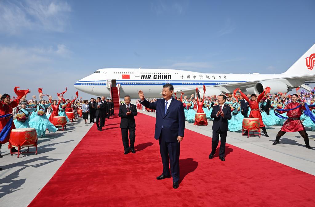 El presidente chino, Xi Jinping, también secretario general del Comité Central del Partido Comunista de China y presidente de la Comisión Militar Central, saluda a una multitud que le aclama a su llegada a Urumqi, en la región autónoma uygur de Xinjiang, en el noroeste de China, el 23 de septiembre de 2025. Xi, encabezando una delegación central, llegó el martes a Urumqi, capital de la región autónoma uygur de Xinjiang, para asistir a las actividades conmemorativas por el 70o aniversario de la fundación de la región. (Xinhua/Xie Huanchi)