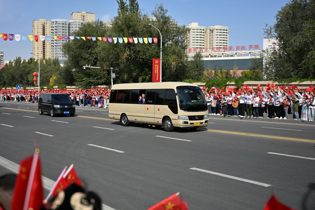 El presidente chino, Xi Jinping, también secretario general del Comité Central del Partido Comunista de China y presidente de la Comisión Militar Central, saluda a multitudes de personas a través de su ventana abierta, en Urumqi, en la región autónoma uygur de Xinjiang, en el noroeste de China, el 23 de septiembre de 2025. Xi, encabezando una delegación central, llegó el martes a Urumqi, capital de la región autónoma uygur de Xinjiang, para asistir a las actividades conmemorativas por el 70o aniversario de la fundación de la región. (Xinhua/Xin Yuewei)