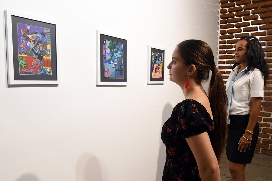Mujeres observan pinturas realizadas por el cineasta y pintor cubano, Juan Padrón, exhibidas en una galería en el marco de la celebración del 65o aniversario del establecimiento de relaciones diplomáticas entre China y Cuba, en el Barrio Chino de la Habana, en La Habana, capital de Cuba, el 24 de septiembre de 2025. (Xinhua/Joaquín Hernández)