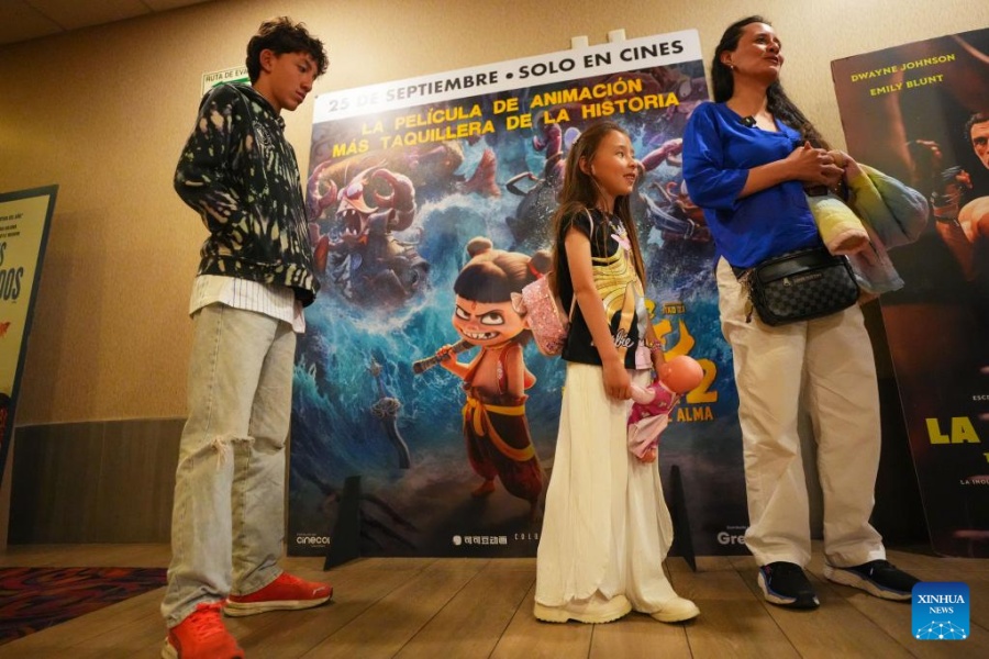 Imagen del 26 de septiembre de 2025 de personas permaneciendo frente a un cartel de la película de animación china "Ne Zha 2" en un cine, en Bogotá, capital de Colombia. Con su arribo a Latinoamérica el 25 de septiembre, los colombianos disfrutan de la exhibición de "Ne Zha 2", la película animada más taquillera de la historia y que ha recaudado de más de 2.000 millones de dólares desde su estreno en China el 29 de enero de 2025. (Xinhua/Andrés Moreno)