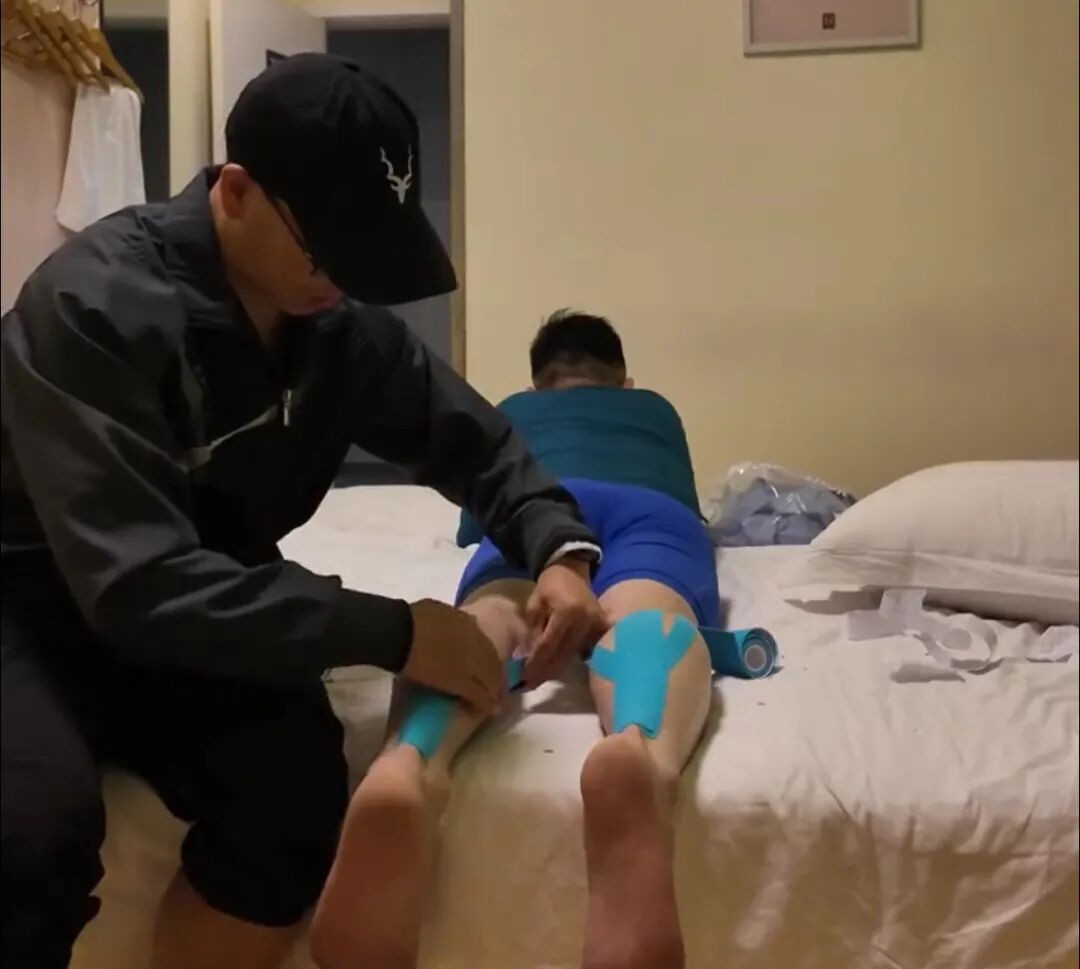 Un compa?ero de carrera ayuda a un participante antes de iniciar el maratón. (Foto: Qianjiang Evening News)