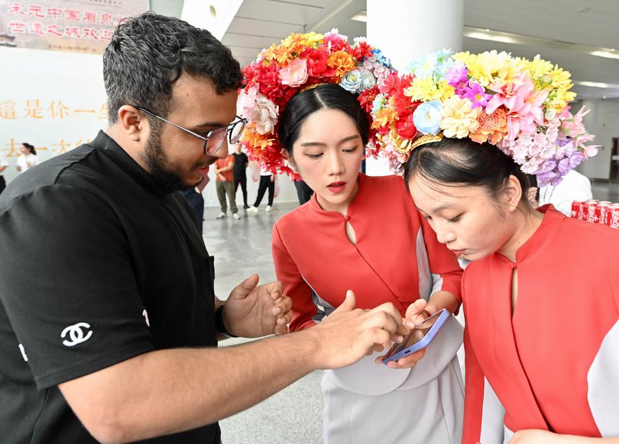 Imagen del 20 de junio de 2025 de trabajadoras ayudando a los extranjeros a usar las aplicaciones locales en el Aeropuerto Internacional Jinjiang de Quanzhou, en Quanzhou, en la provincia de Fujian, en el sureste de China. (Xinhua/Jiang Kehong) 