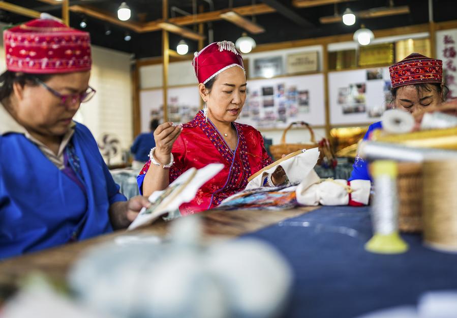 Long Luying (c) elabora una pieza en el taller de bordados del distrito de Shibing, en la prefectura autónoma de las etnias miao y dong de Qiandongnan, en la provincia suroccidental china de Guizhou, el 10 de octubre de 2025. (Xinhua/Tao Liang)