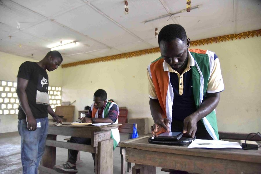 Imagen de archivo del 22 de octubre de 2024 de trabajadores registrando información para los electores en un centro de registro de votantes, en Abiyán, Cote d'Ivoire. (Xionhua/Yvan Sonh) 