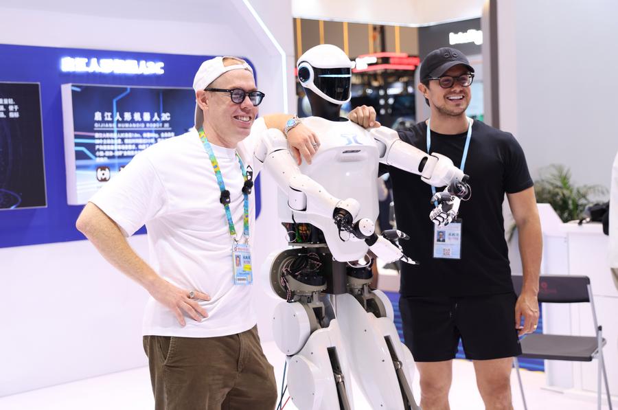 Imagen del 15 de octubre de 2025 de compradores extranjeros posando para una fotografía grupal con un robot humanoide en la Zona de Robots de Servicio durante la 138a edición de la Feria de Importación y Exportación de China (Feria de Cantón), en Guangzhou, en la provincia de Guangdong, en el sur de China. (Xinhua/Lu Hanxin) 